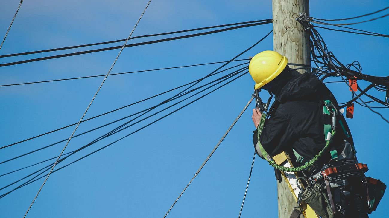 Lineman working at the top of a utility pole
