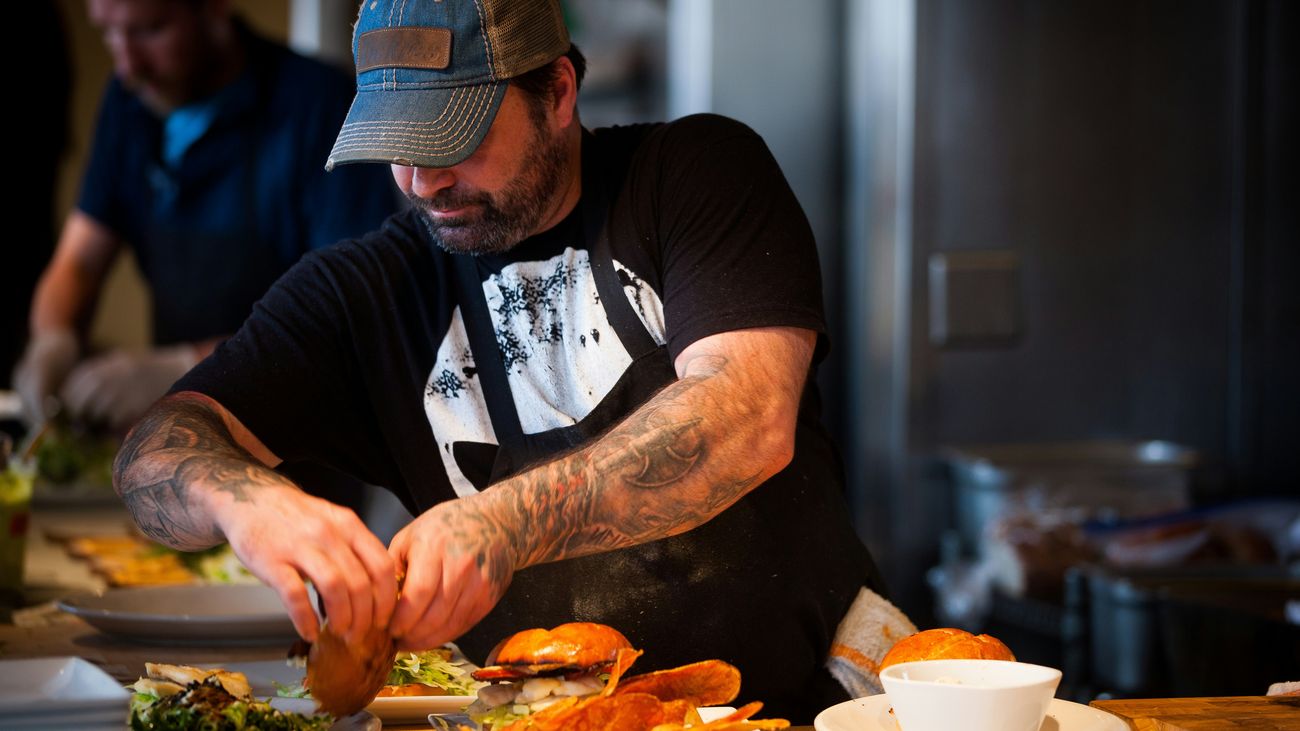 Chef plating dishes in a small restaurant kitchen